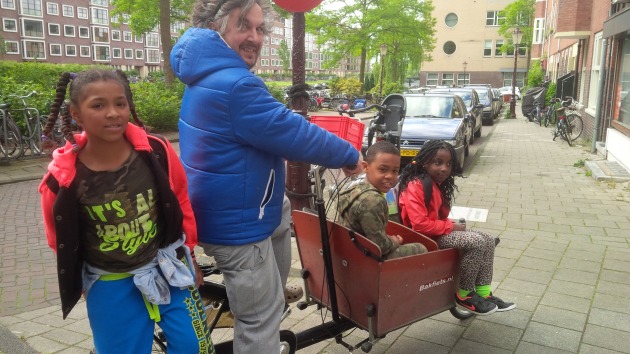 A father with his children in their cargo bike. It's perfectly safe to travel this way because there is safe cycling infrastructure all over the city.